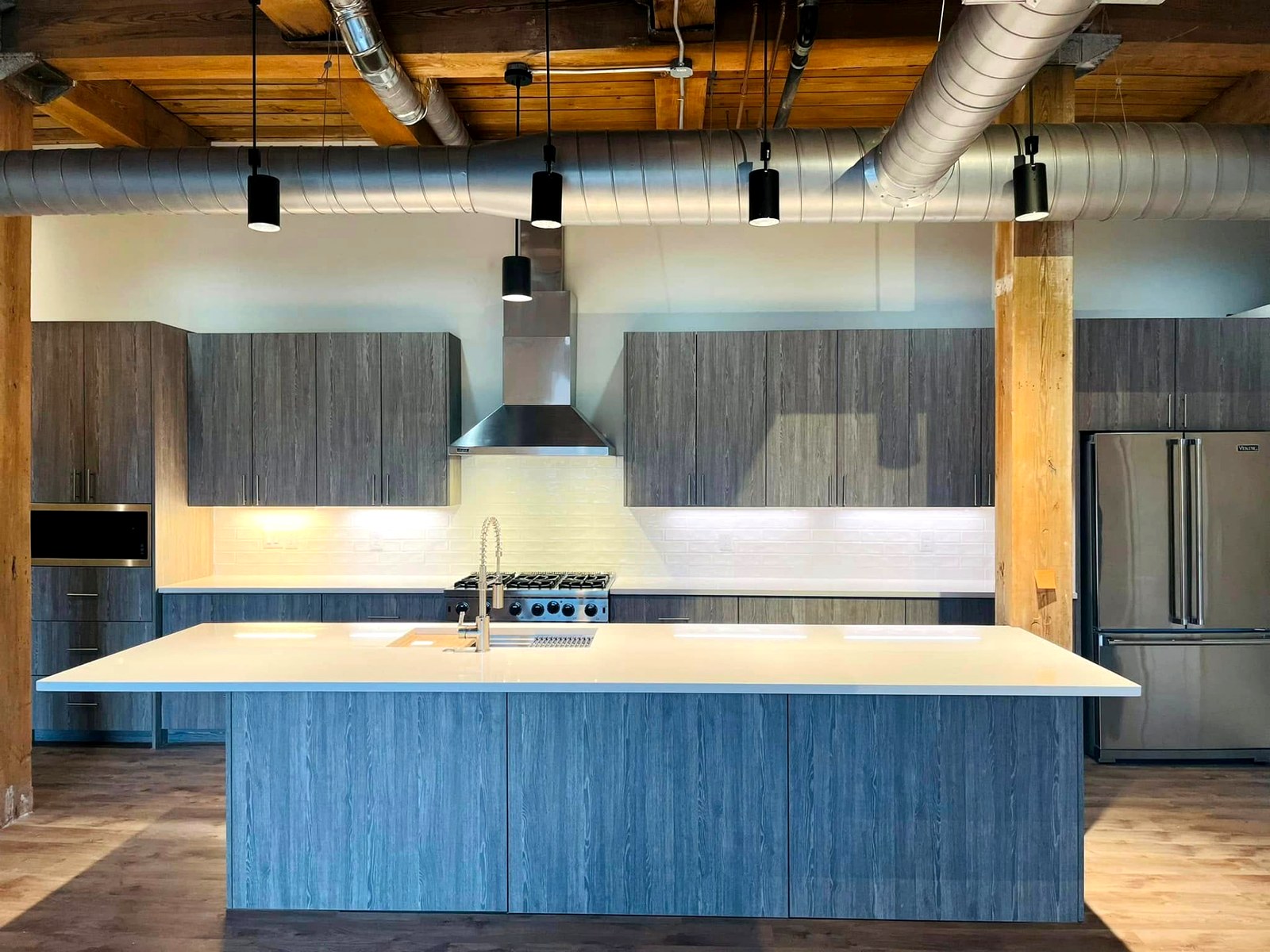 Euro-style loft kitchen with weathered grey slab cabinets and quartz island