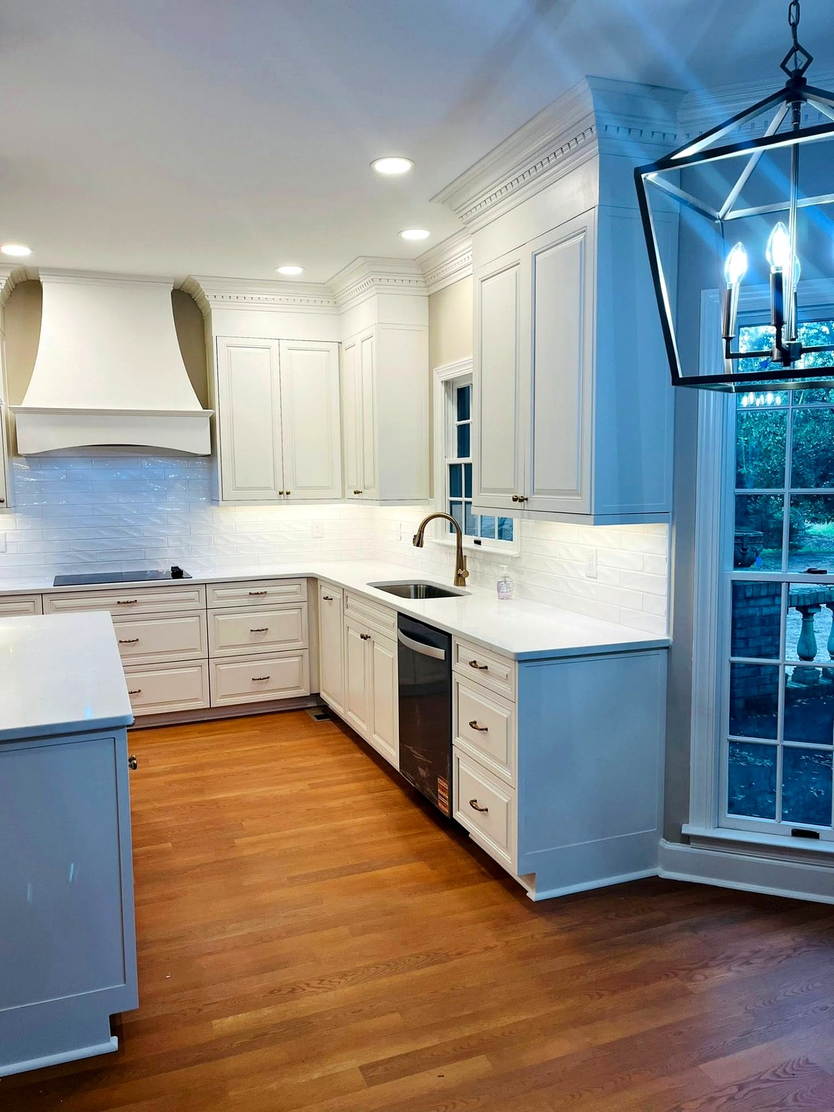 Classic raised panel white kitchen cabinets with curved range hood