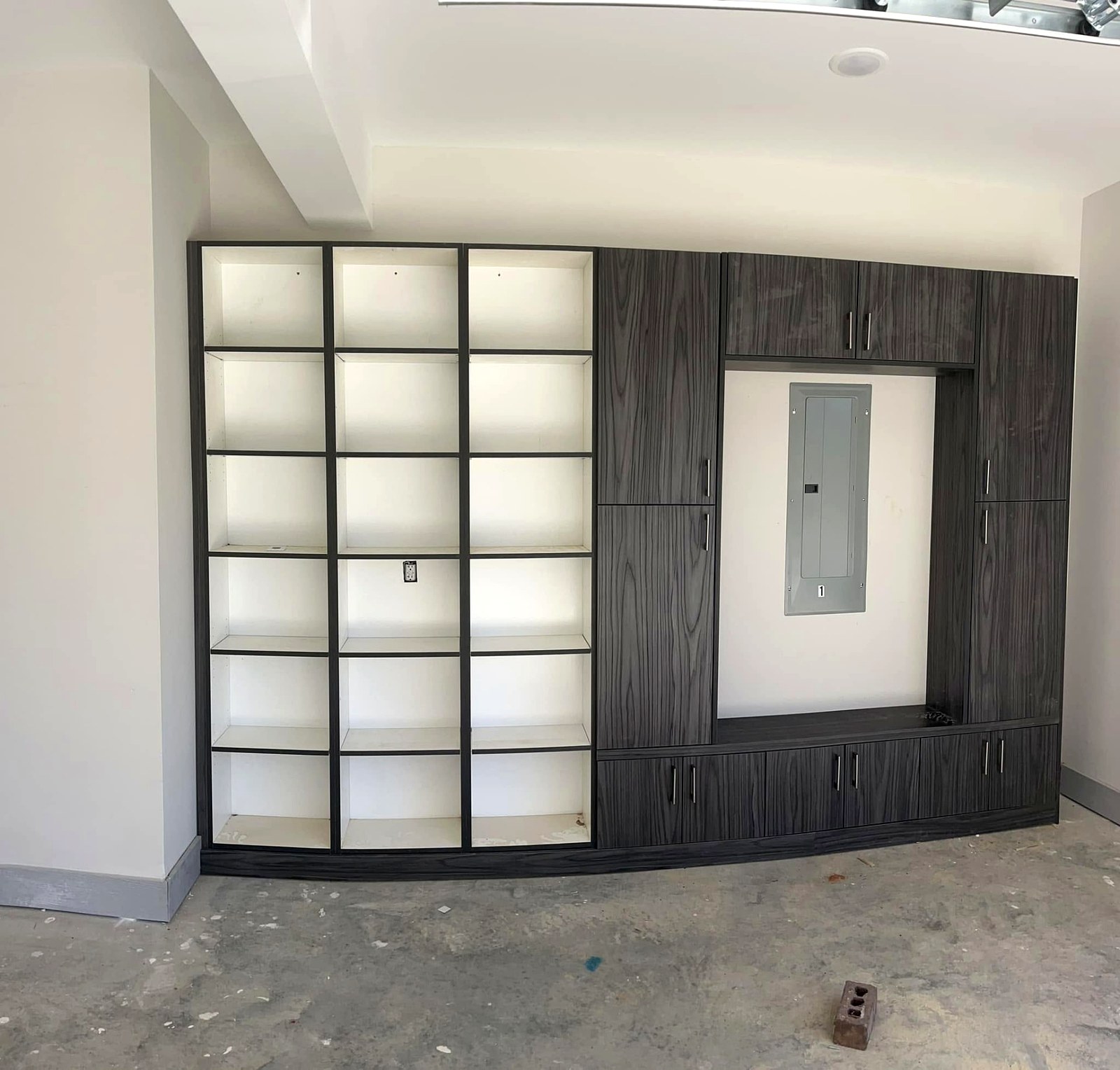 Grey woodgrain built-in shelving and storage cabinetry wall