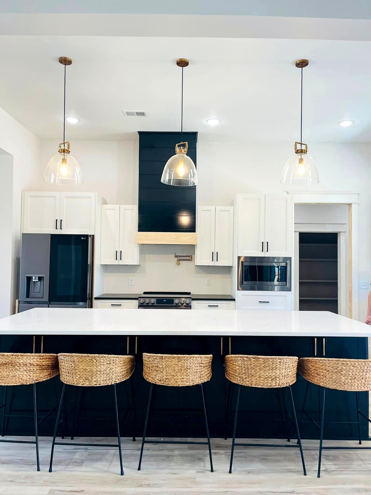 Navy island kitchen with white shaker prefab cabinets supplied by Southern Dew Woodworks
